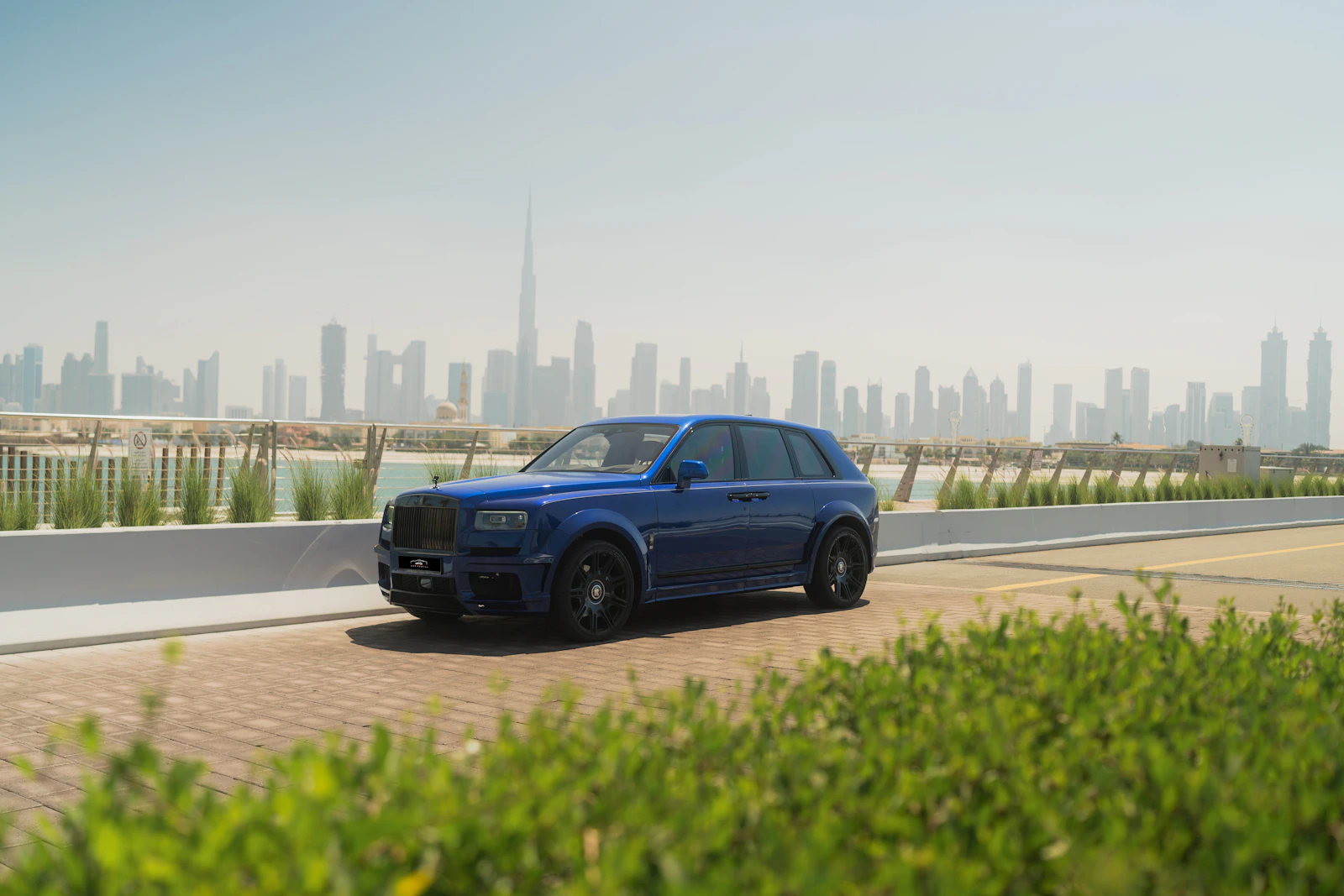 Blue Rolls-Royce Cullinan in front of the Dubai skyline and Burj Khalifa